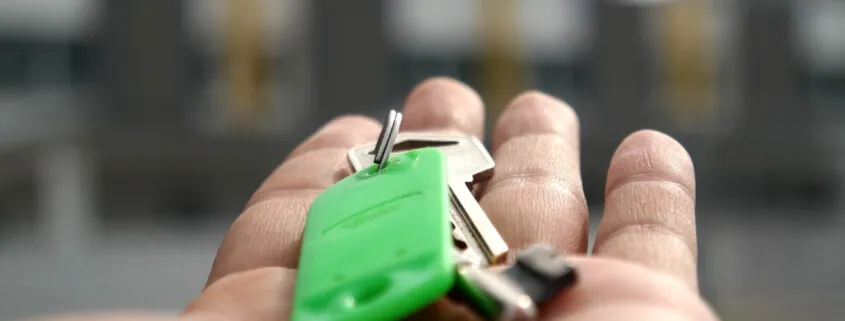 Keys on hand with green keychain