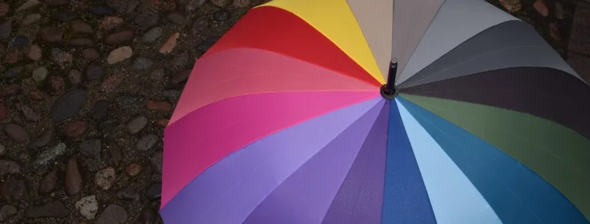 Multicolored umbrella on rocky ground